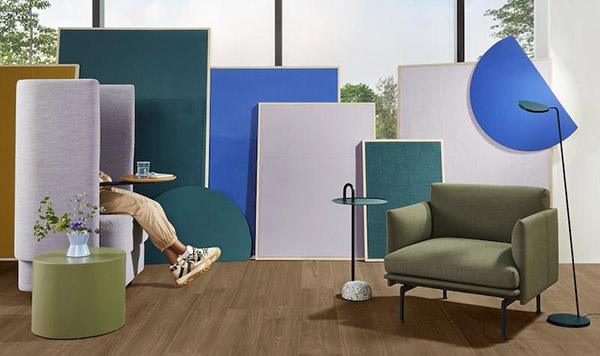 rendering of the flooring with furniture, person sitting in chair, large windows behind