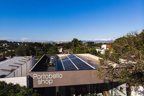 view of the Portobello Shop’s roof covered in a peaked solar array, expanse of trees and buildings in the background